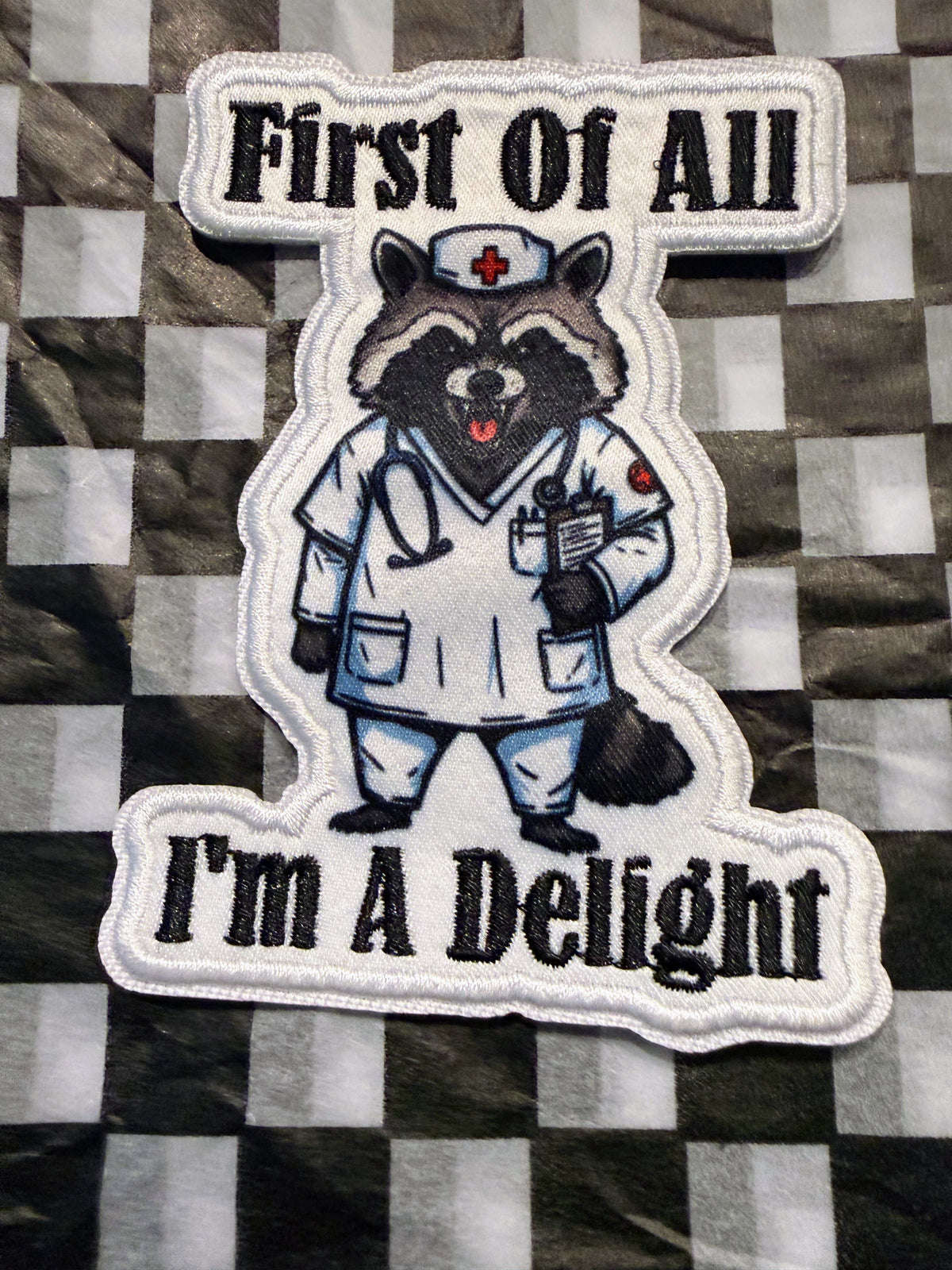 Cute, chaotic, and just a little bit sassy! This “First of All, I’m a Delight” iron on raccoon patch